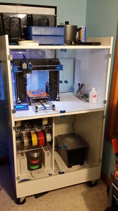 a 3d printer sitting on top of a white cabinet