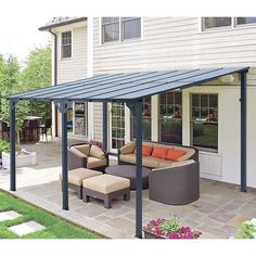 a covered patio with furniture and flowers in the foreground