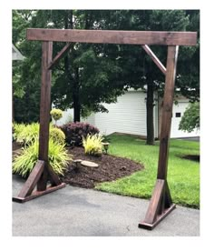 a wooden arbor in the middle of a yard