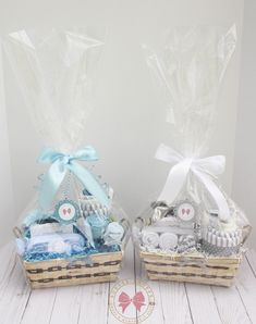 two baskets filled with baby items sitting on top of a white wooden floor next to each other