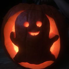 a carved pumpkin with a face and hands on it