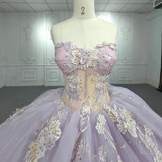 a mannequin is dressed up in a purple and white dress with flowers on it