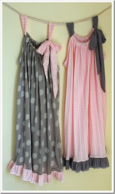 two dresses hanging up against a wall with polka dots on the bottom and one in pink, grey and white