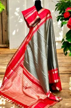 Expertly handcrafted with traditional korvai technique, the Kanjivaram Silk Saree boasts a luxurious sage grey body and stunning red border and pallu. With intricate grand threadwork, this saree exudes elegance and sophistication. Elevate your wardrobe with this timeless and exquisite piece of Indian heritage. The blouse piece is elegantly hand embroidered to match the saree. Approximate Length 6.5 mtrs (inclusive of blouse length) Approximate Height - 46 - 48" Approximate weight - 1.5 lbs Saree comes with fall, picot and tassels done when applicable. Blouse piece is cut. Kindly Note : The colors you see on your device may vary due to the color reproduction, brightness and resolution of individual devices. If you'd like more clarity before your purchase, please contact our support team. Kanjivaram Silk Saree, Red Border, Silk Cotton Sarees, Indian Heritage, Cotton Sarees, Blouse Length, Support Team, Blouse Piece, Cotton Saree