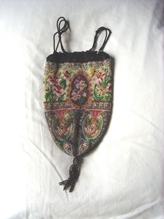 Collectors Victorian Purse Micro-beaded Floral Tapestry Design in rich jewel tones. The design is the same front & back with no missing beads, a beaded tassel finishes the pointed bottom,the black crocheted top edge is also banded with jet beads, & a black cord drawstring closes the purse.  The inside silk lining is in perfect condition which not the usual case. This Victorian Gem is a rare find and has been a part of my collection for 20+ years, the first time offered for sale on Etsy.  Size: 8" body + 2 1/2" tassel, 5 1/2" across the top half of the body. Insurance Included in shipping Victorian Purses, Black Crochet Top, Floral Tapestry, Black Crochet, Tapestry Design, Jewel Tones