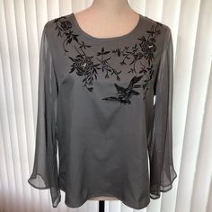 This Exquisitely Embroidered Grey Top Feels Like Fine Silk But Is An Easy Care Polyester. Long Flared Sleeves Are In A Gauze Like Fabric. Has A Black And Gold 8” Zipper Detail At Back Neckline And Measures 20” Across The Darted Bust And 24” From Shoulder Seam To Hemline In The Front With An Extra 1” Length In The Back. Really Beautiful-It Could Be Dressed Up With Pearls Or Worn Casually With Jeans. Can You Tell I Love This Top! Brand New Condition, Size M By Angie. Spring Embroidered Gray Tops, Grey Top, Zipper Detail, Flared Sleeves, Black And Gold, Black And Grey, Dress Up, Long Sleeves, Womens Tops