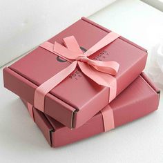 two pink boxes with ribbons tied around them