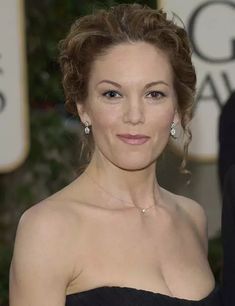 a woman in a strapless black dress posing for the camera with her hand on her hip