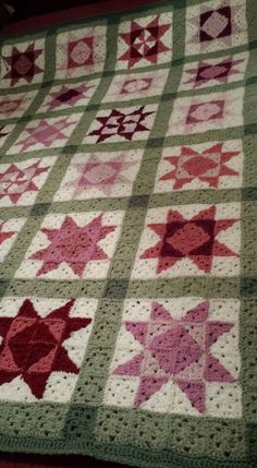 a crocheted blanket with red and pink stars on it