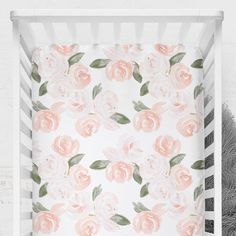 a white crib with pink roses on it