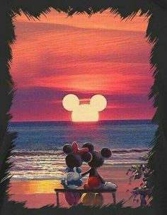 mickey and minnie mouse sitting on a bench at the beach watching the sun go down