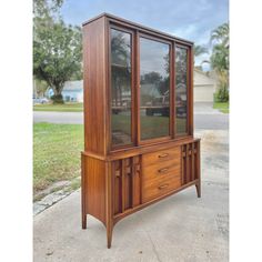 a wooden cabinet sitting on top of a sidewalk