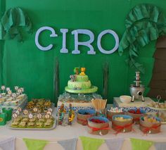 a table topped with lots of desserts and cupcakes next to a sign that says ciro