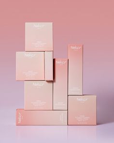 five pink boxes stacked on top of each other in front of a pink background,