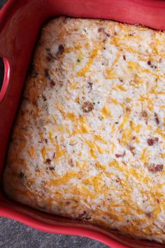 a red casserole dish filled with cheese and meat