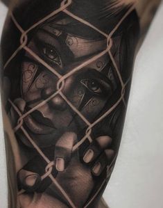 a man's arm with a tattoo on it that has an image of a woman behind a chain link fence