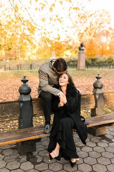 a man kneeling down next to a woman on a bench