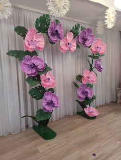 two large paper flowers are on display in the middle of a room