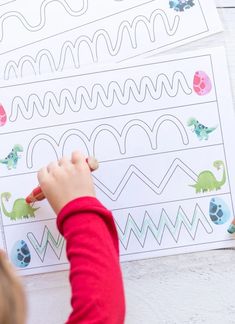 a little boy is drawing on some paper