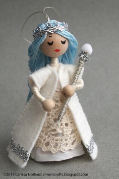 a doll with blue hair holding a wand