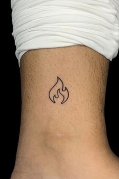 a small tattoo on the back of a woman's neck, with a fire symbol