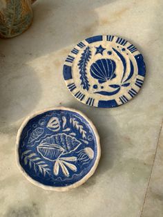 two blue and white plates sitting next to each other on top of a marble counter