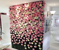 pink and white flowers are arranged on the wall