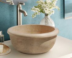 a bowl shaped sink sitting on top of a counter next to a bathroom faucet