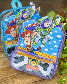 two toy story backpacks sitting on top of a wooden table