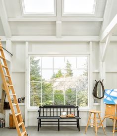 a room with a ladder, window and bench in it