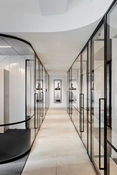 an empty hallway with glass walls and black accents