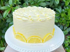 a white cake with lemons and icing on a plate