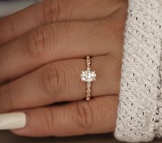 a woman's hand with a diamond ring on it