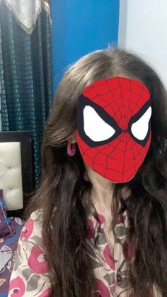 a woman with long hair wearing a spiderman mask