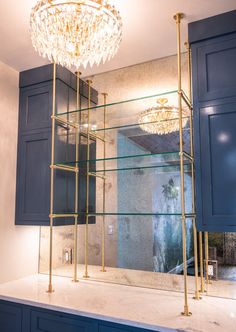 a bathroom with blue cabinets and a chandelier hanging from the ceiling above it