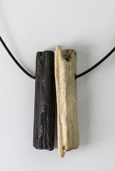 two pieces of driftwood hanging on a black cord