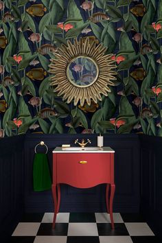 a bathroom with a red vanity and green wallpaper