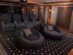 an empty theater room with black chairs and gold stars on the carpeted flooring