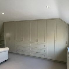 an empty room with white cabinets and drawers