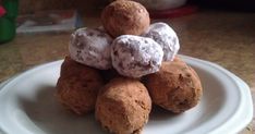 a white plate topped with chocolate covered donuts