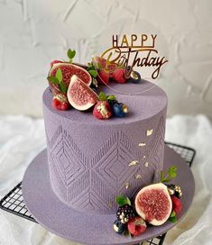 a purple birthday cake with fresh fruit on top