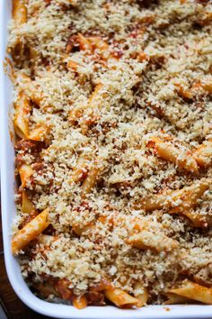 a casserole dish filled with pasta and meat covered in parmesan cheese