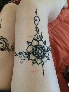 two women with tattoos on their legs sitting next to each other and one has a flower tattoo on her arm