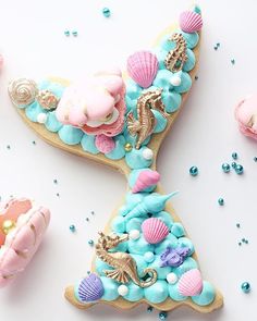 there is a decorated letter made out of cookies and sea shells on the table with confetti