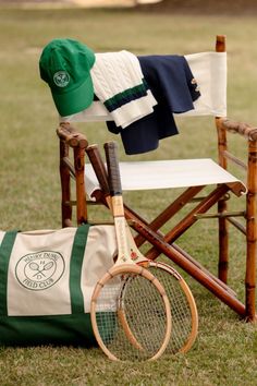 a tennis racket sitting on top of a chair next to a hat and racquet