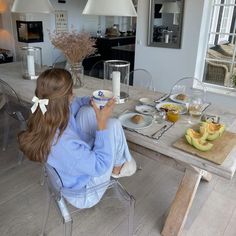 a woman sitting at a table eating breakfast