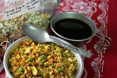 a bowl filled with rice and vegetables next to a cup of coffee on a table