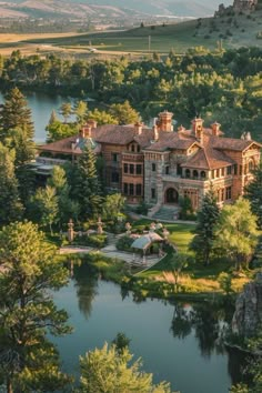 an aerial view of a large mansion surrounded by trees and water in the middle of a wooded area