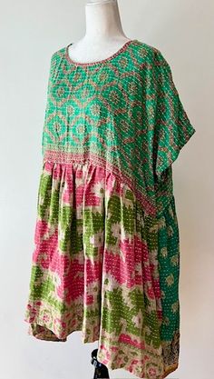 Artisan Kantha Bae Quilt Mini Dress. Dress falls just above the knee. With a high low hem, the dress is perfect for all ages. Soft, and Very Chic. An absolute favorite in daytime dresses. Why do we love it? Our best selling dress has been the midi version. Now... the shorter mini has been created. Now a best seller, surpassing the midi. This dress is a perfect example of maximizing the use of mixed prints to achieve a sophisticated fashion statement.The style is fresh, mixed prints engineered cr Bohemian Tunic With Asymmetrical Hem For Spring, Spring Bohemian Tunic With Asymmetrical Hem, Lagenlook Tunic Dress For Festivals, Green Short Sleeve Dress For Festivals, Festival Lagenlook Tunic Dress, Bohemian Cotton Dress With Asymmetrical Hem, Spring Festival Lagenlook Dresses, Sophisticated Fashion, Mixed Prints