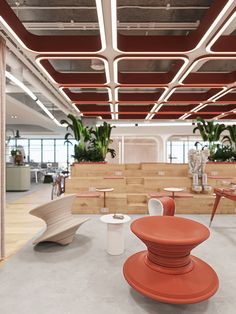 the interior of an office building with orange chairs and planters on the walls,